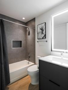 a bathroom with a tub and a toilet and a sink at Chaparral - 2 Units - Jacuzzi - Heart of Old Town in Scottsdale