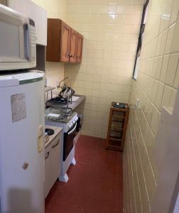 a small kitchen with a stove and a microwave at Apartment two blocks from the sea, in the center of Torres in Torres