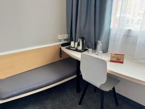 ザブジェにあるIbis Katowice - Zabrzeの窓際に椅子とデスクが備わる客室です。
