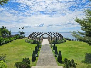 a pathway through a garden with a view of the ocean at Savoy Hotel Mactan Cebu near Newtown Beach in Mactan