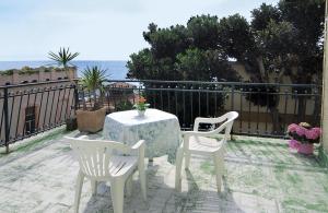 een tafel en stoelen op een balkon met uitzicht op de oceaan bij Albergo Savoia in Ospedaletti