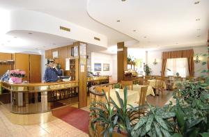 a lobby with a person standing in a restaurant at Albergo Savoia in Ospedaletti