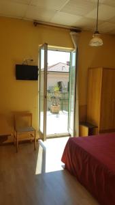 een slaapkamer met een bed en een glazen schuifdeur bij Albergo Savoia in Ospedaletti
