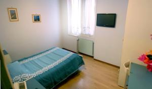 een slaapkamer met een bed en een televisie. bij Albergo Savoia in Ospedaletti