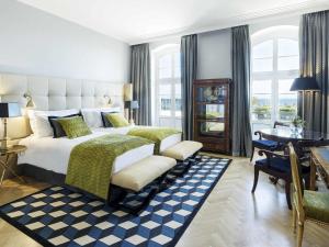 a bedroom with a king sized bed and a desk at Sofitel Grand Sopot in Sopot
