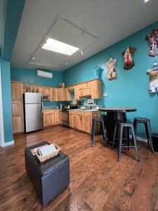 a large kitchen with wooden cabinets and a blue wall at 420 LOFT in Glenwood Springs