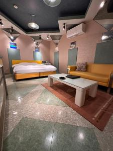 a bedroom with a bed and a couch and a table at ホテルエリーゼマリオットHotel ELISE MARRIOTTO in Tsuruoka