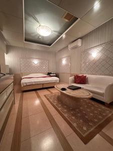 a bedroom with a bed and a couch and a table at ホテルエリーゼマリオットHotel ELISE MARRIOTTO in Tsuruoka