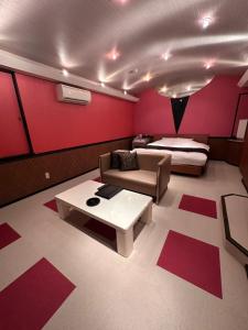 a bedroom with a bed and a couch and a table at ホテルエリーゼマリオットHotel ELISE MARRIOTTO in Tsuruoka