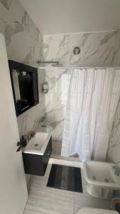 a bathroom with a sink and a toilet and a shower at Studio Arena y Sol - MDQ Güemes in Mar del Plata