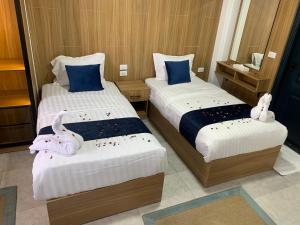 Dos camas con animales de peluche encima en una habitación. en Kanz Pyramids Inn, en El Cairo 2 fotos más
