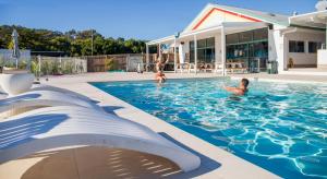 a group of people swimming in a swimming pool at Freedom Backpackers Hostel Rainbow Beach in Rainbow Beach