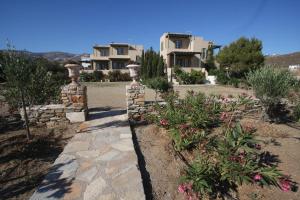 a house with a stone pathway in front of a yard at K - Homes in Tinos Town