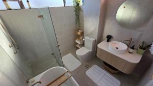 Un baño con ducha, inodoro y lavabo. en Le Blu Mile apartement, en Wollongong