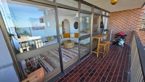 Ofrece vistas a una sala de estar con ventanas de cristal. en Le Blu Mile apartement, en Wollongong 8 fotos más