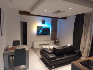 a living room with a couch and a table at Badoumkassa in Welkenraedt