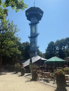 a clock tower in a park with tables and chairs at Badoumkassa in Welkenraedt