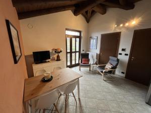 a living room with a tv and a table and chairs at Case Vista Alta Langa in Cravanzana