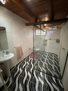 a bathroom with a zebra print shower and a sink at Sitio Mangala in Itapeva