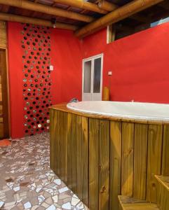 a bathroom with a red wall and a bath tub at Sitio Mangala in Itapeva