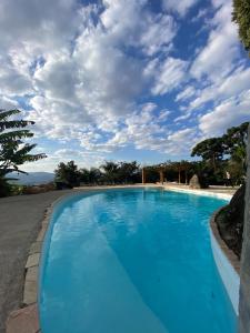 a blue swimming pool under a cloudy sky at Sitio Mangala in Itapeva