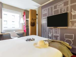 a room with a bed with a hat on it at ibis Hotel Hamburg St. Pauli Messe in Hamburg