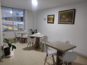 a dining room with tables and chairs and a window at Hotel Konfort Inn in Cali