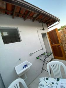 a patio with a table and chairs and a sink at Apartamento moderno perto do centro e praia! in Búzios +3 photos