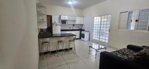 a living room with a couch and a kitchen at Casa Aconchegante in Cuiabá