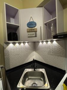 a kitchen counter with a sink and lights above it at Avida Towers Davao Condotel in Davao City +9 photos