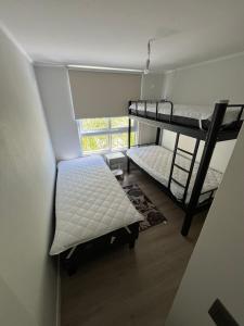 two bunk beds in a room with a window at Bosque y mar de Papudo in Papudo