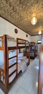 a room with three bunk beds in a house at Elisa Hostel in Kuta Lombok