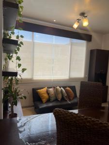 a living room with a couch and a window at Kennedy Norte Suites in Guayaquil