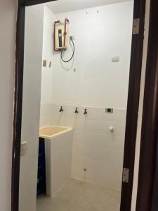 a white bathroom with a sink and a shower at Kennedy Norte Suites in Guayaquil +5 photos