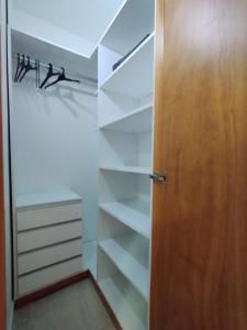 a closet with white shelves and a wooden door at Catalina - Excelente ubicacion en pleno centro - 1B in Santa Fe
