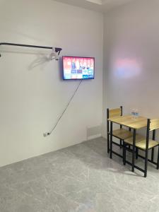 a dining room with a table and a tv on the wall at Casa Mia Apartments in Villasis
