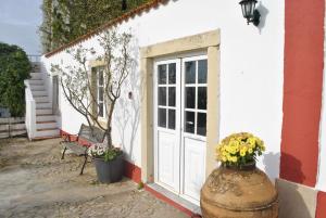 a white building with a door and flowers in a pot at Quinta de Sao Filipe in Setúbal