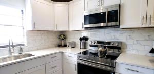a kitchen with white cabinets and a stove top oven at Lovely House in Sarasota close to UTC Mall Nathan Benderson Park and Siesta Key Beach in Sarasota