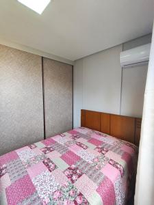 una camera con una trapunta rosa su un letto di Apartmento em Castelhanos a 50 metros da praia a Anchieta Altre 4 foto