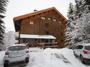 two cars parked in front of a building in the snow at Appartement chaleureux près des pistes à Méribel - FR-1-688-100 in Mussillon