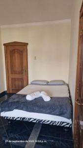 a bedroom with a bed with two white towels on it at Casa blanca alojamientos in Manta