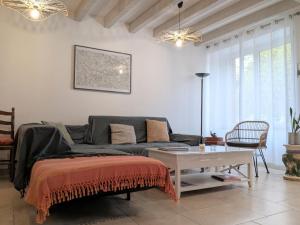un soggiorno con un divano e un tavolo di Maison spacieuse avec terrasse couverte et parking en région naturelle - FR-1-591-764 a Méobecq