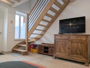 un soggiorno con scala e TV a schermo piatto di Maison spacieuse avec terrasse couverte et parking en région naturelle - FR-1-591-764 a Méobecq