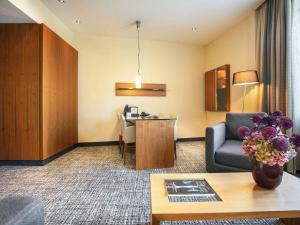 a hotel room with a couch and a table at Pullman Eindhoven Cocagne in Eindhoven