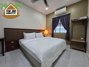 a bedroom with a large bed and a window at Homestay Tok Ani by Ardzman Hospitality in Permatang Pauh