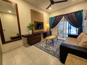 a living room with a couch and a table and a television at Homestay Tok Ani by Ardzman Hospitality in Permatang Pauh