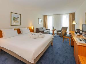 Кровать или кровати в номере Novotel Freiburg am Konzerthaus +71 фотография