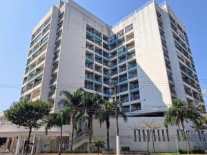 a tall white building with palm trees in front of it at Wise SP Expo Center e Anhembi in São Paulo