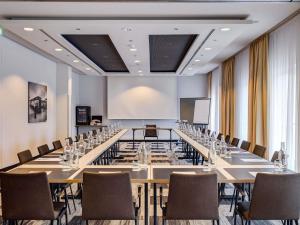 a large conference room with a long table and chairs at Mercure Hotel Hamburg Mitte in Hamburg