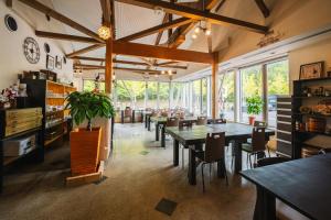 a dining room with tables and chairs and windows at みずほガーデンロッジ in Kyotamba